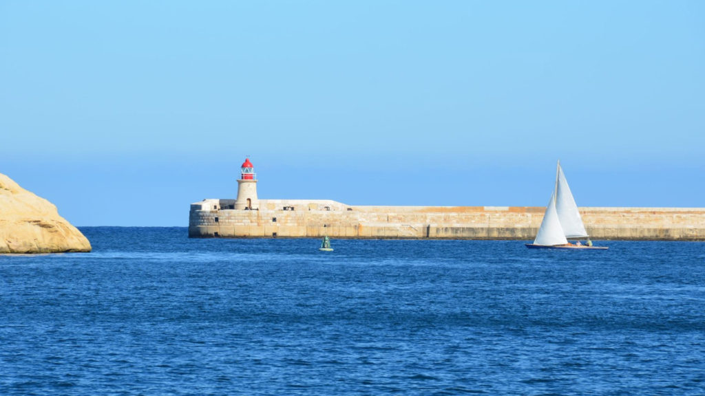 A sailboat leaves the Grand Harbour in Valletta, Malta