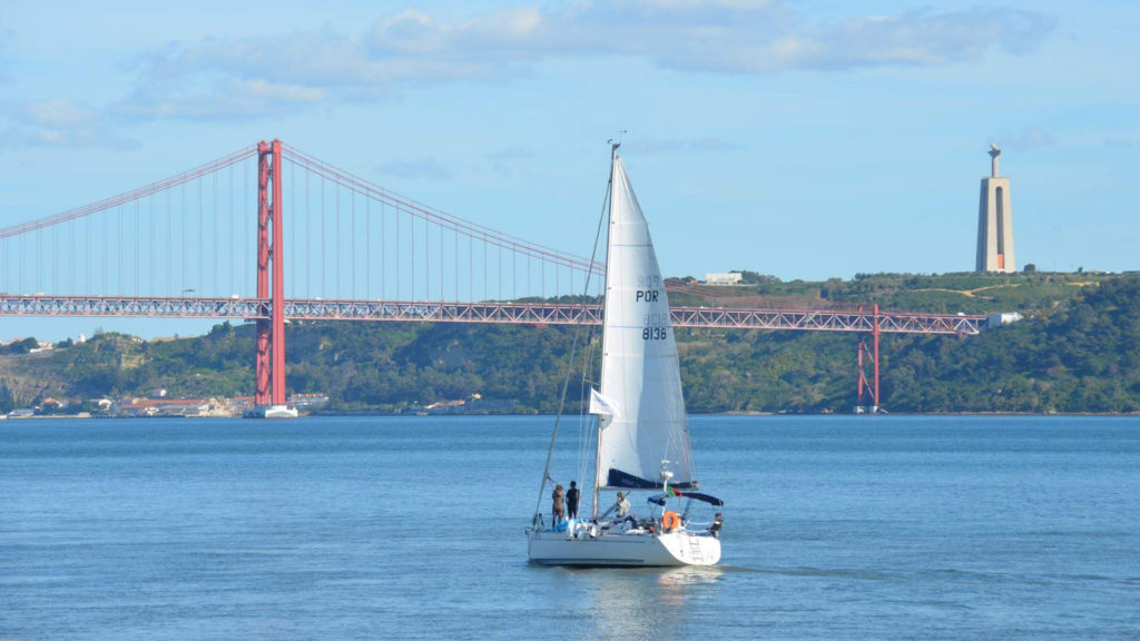 A sailboat enters Lisbon harbor in Portugal.